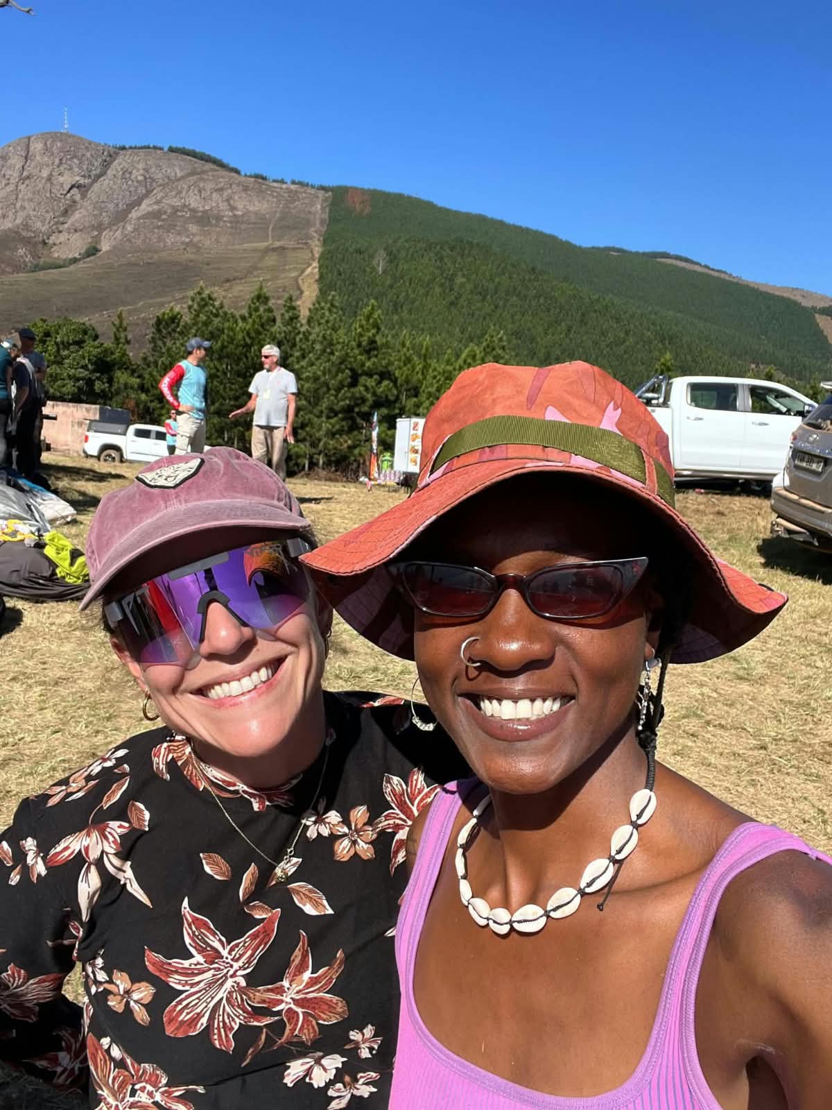 Two smiling hikers at a Barberton mountain event with the Makhonjwa peak behind them