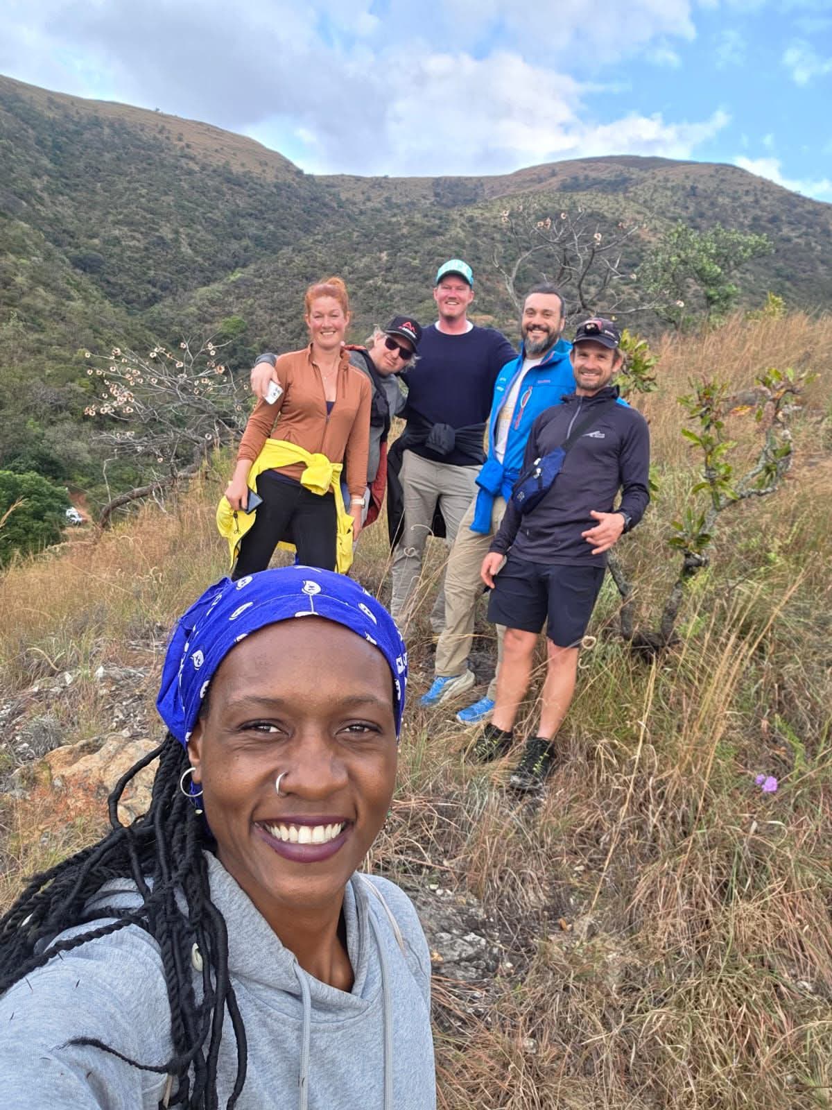 A group of hikers walking a green Makhonjwa mountain trail together